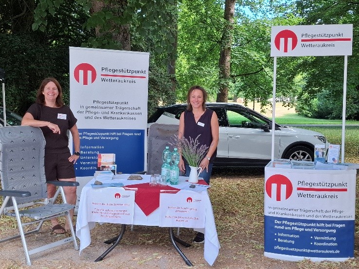 Zwei Frauen stehend an einem Infostand in freier Natur