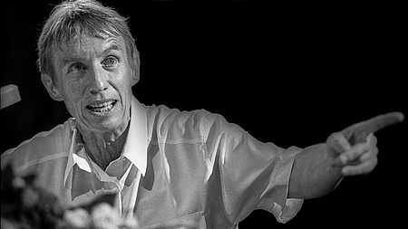 Ein Frau mit kurzen Haaren und mittleren Alters spricht und gestikuliert.