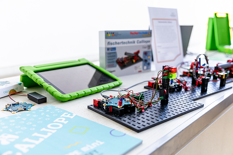 Calliope mini V2 und fischertechnik mit einem iPad und Informationsmaterialien