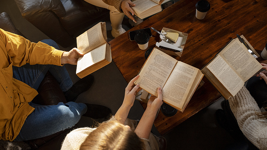 Menschen sitzen in einer Runde und lesen