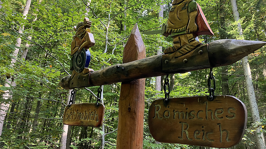 Ein Wegweiser in einem Wald.
