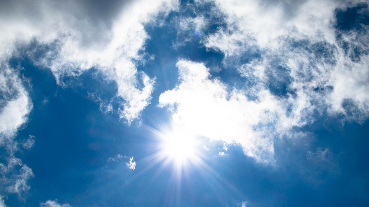Blauer Himmel mit Wolken und Sonnenschein