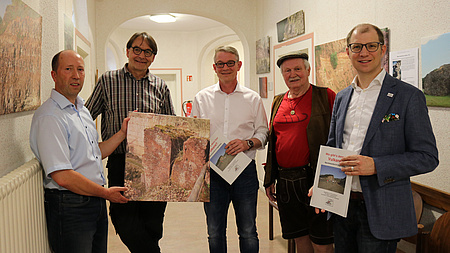 Personengruppe im Flur der Verwaltungsstelle Büdingen. Einige halten Broschüren und ein großformatiges Foto in Händen