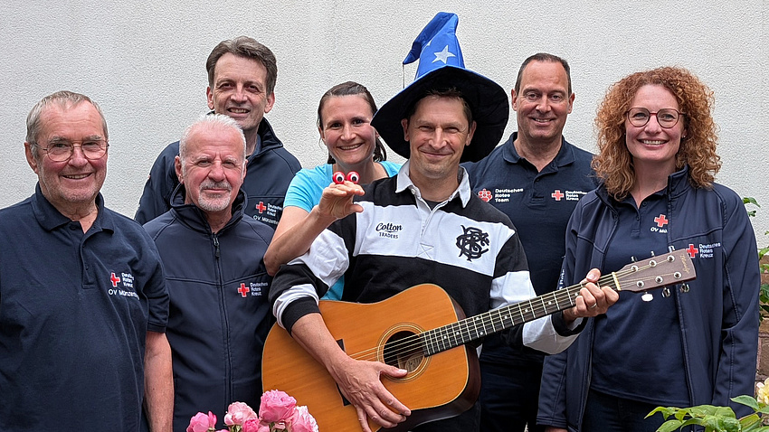 Eine Gruppe Menschen, eine mit Gitarre