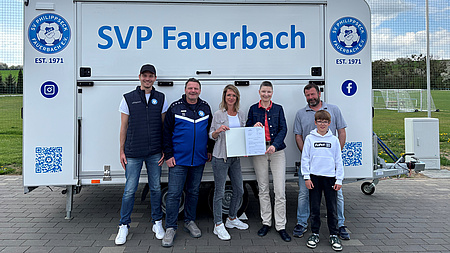 Sechs Menschen vor einem Wagen mit der Aufschrift "SVP Fauerbach".