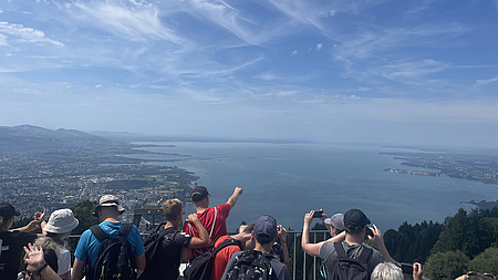 Gruppe Jugendlicher schaut von Aussichtsplattform auf den Bodensee