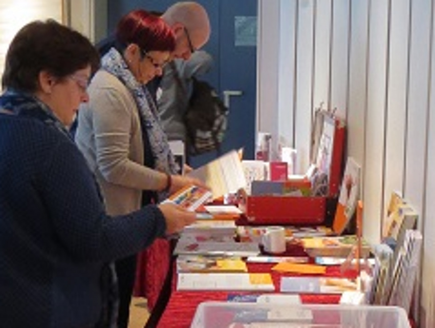 Teilnehmende betrachten sich den Büchertisch