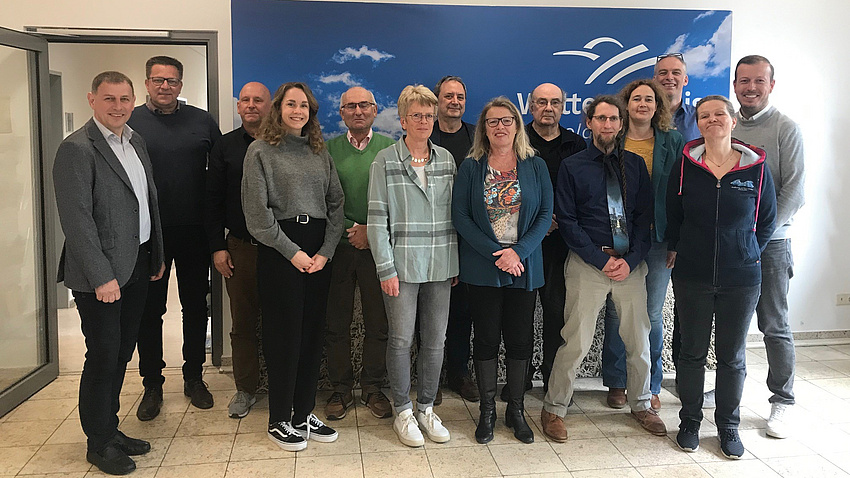 Mehrere Personen stehen nebeneinander und lächeln in die Kamera.