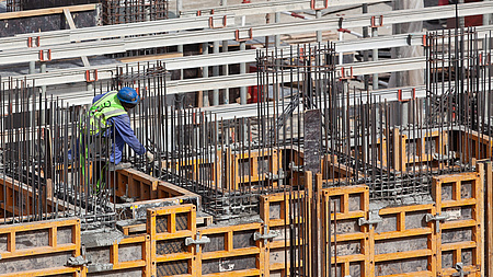 Ein Bauarbeiter bereitet auf einer Baustelle das Gießen von Betonwänden vor.