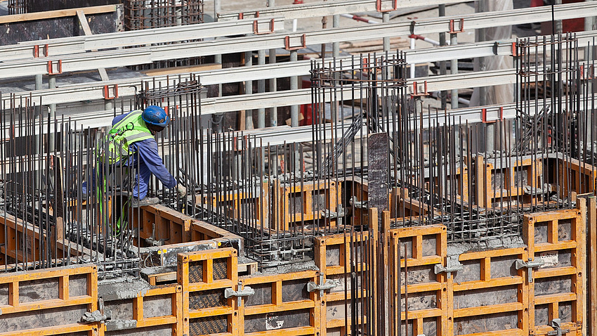 Ein Bauarbeiter bereitet auf einer Baustelle das Gießen von Betonwänden vor.