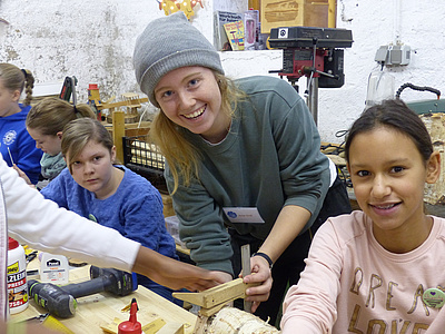 Mädchen arbeiten mit Holz an einer Werkbank