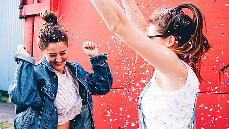 Zwei mädchen tanzen mit Konfetti