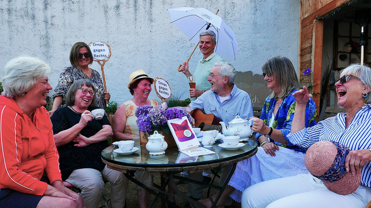 Eine Gruppe fröhlicher Menschen sitzt an einem Tisch