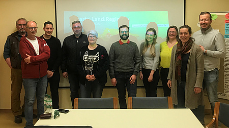 Eine Gruppe von Männern und Frauen lächelt in die Kamera.