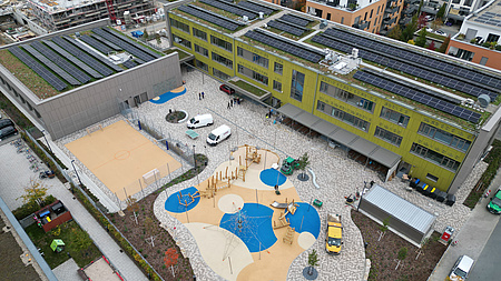 Die Drohnenaufnahme zeigt die neu gebaute schule und den Schulhof von oben.