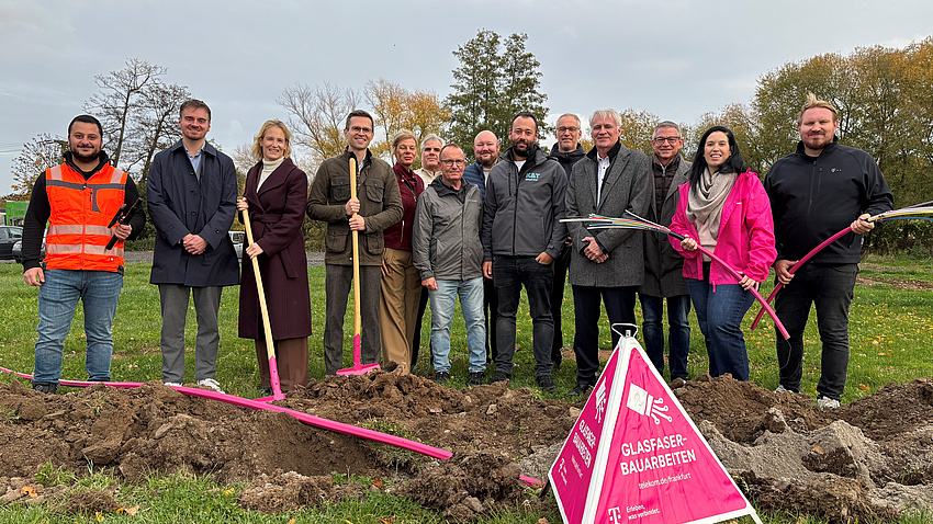 Eine große Gruppe von Menschen steht vor einem langen Graben.