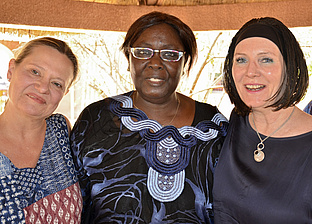 Eine schwarze Frau in der Mitte mit zwei weißen Frauen rechts und links von ihr