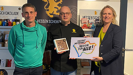 Die Sozialdezerntin hält das Logo hoch.