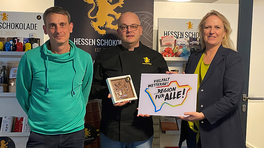 Die Sozialdezerntin hält das Logo hoch.