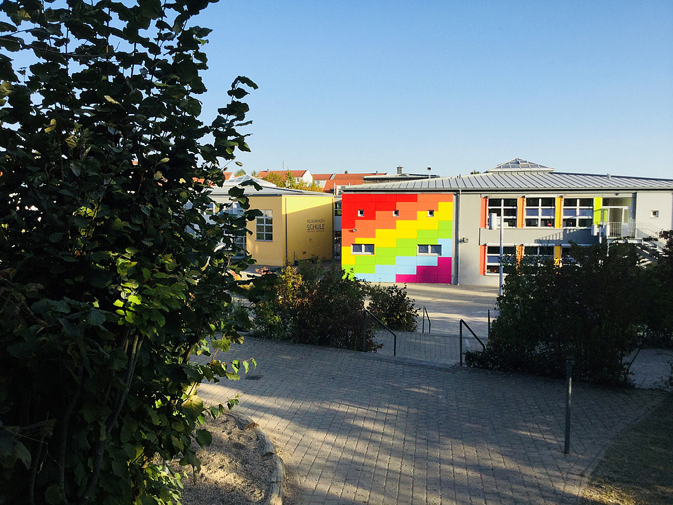 Die Fassade der REgenbogenschule ist mit REgenbogenfarben verziert
