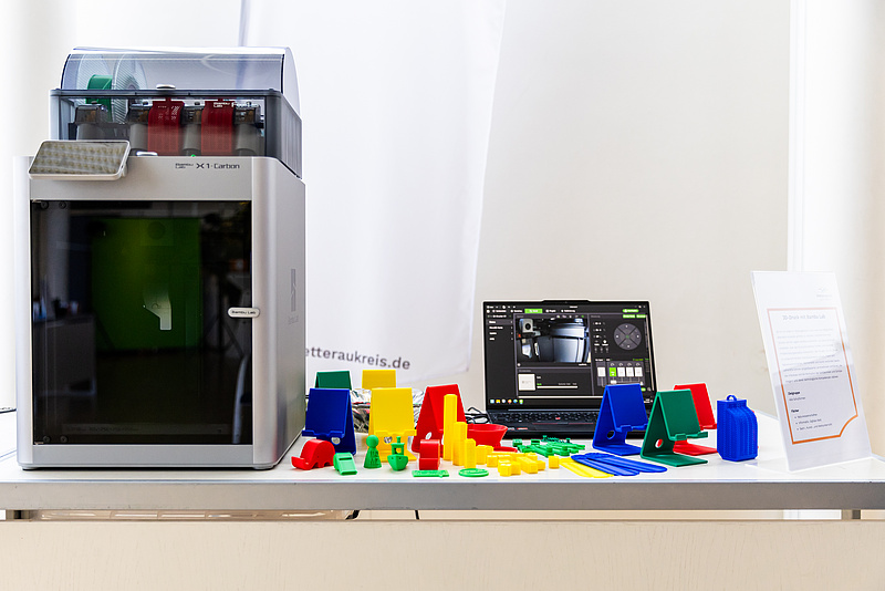 Ein 3D-Drucker mit ausgedruckten Produkten