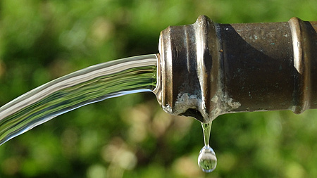 Frisches Wasser kommt aus einem Brunnen.