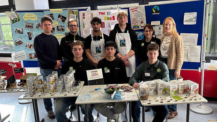 Mehrere Menschen stehen hinter einem Infostand.
