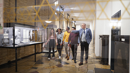 Mehrere Juden laufen durch ein Museum.
