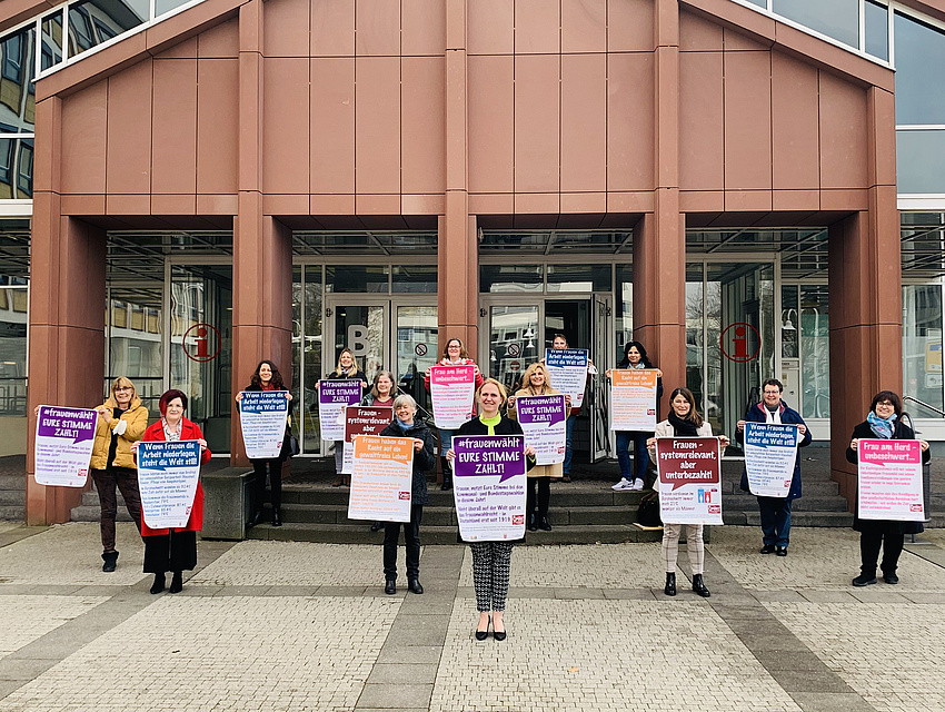 Vertreterinnen von Frauenorganisationen präsentieren vor dem Haupteingang des Kreishauses mit Plakaten in der Hand