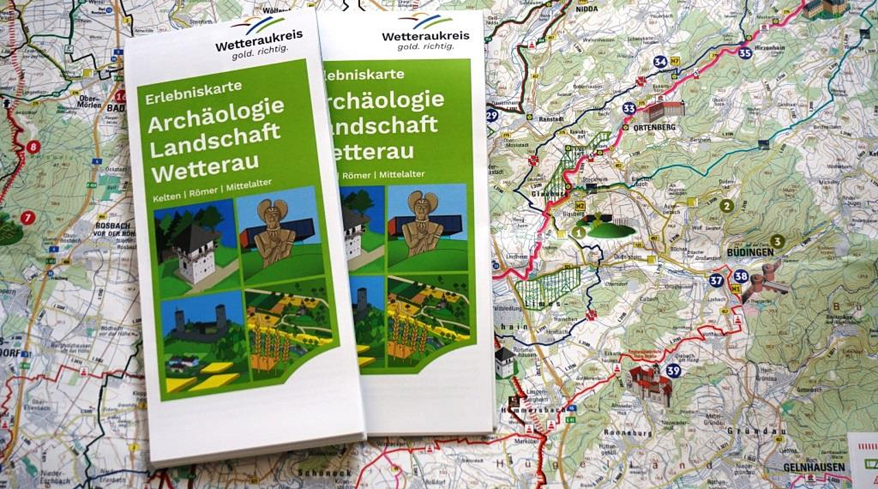 Zwei Flyer liegen auf einer Landerlebniskarte