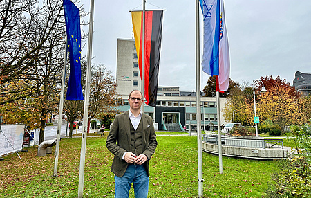 Landrat Weckler vor den Flaggen
