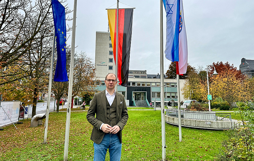 Landrat Weckler vor den Flaggen