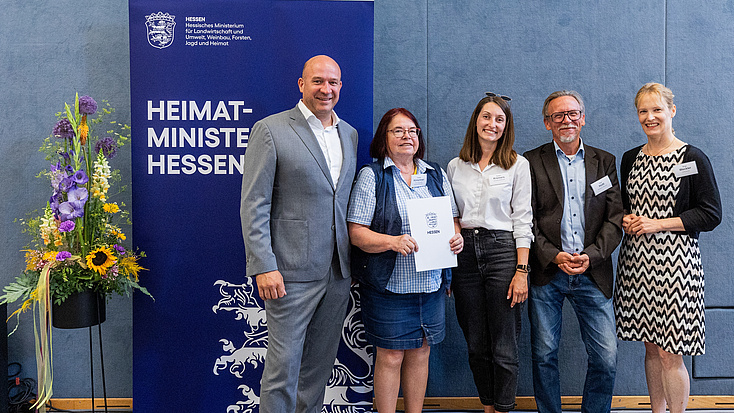 Fünf Menschen lächeln begeistert in die Kamera und halten ein Zertifikat