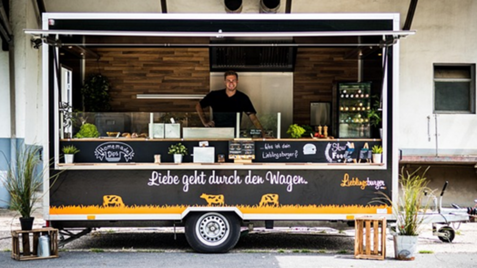 Aufgeklappter Burger-Verkaufswagen mit einer Person