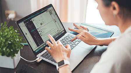 Eine Frau an einem Laptop.