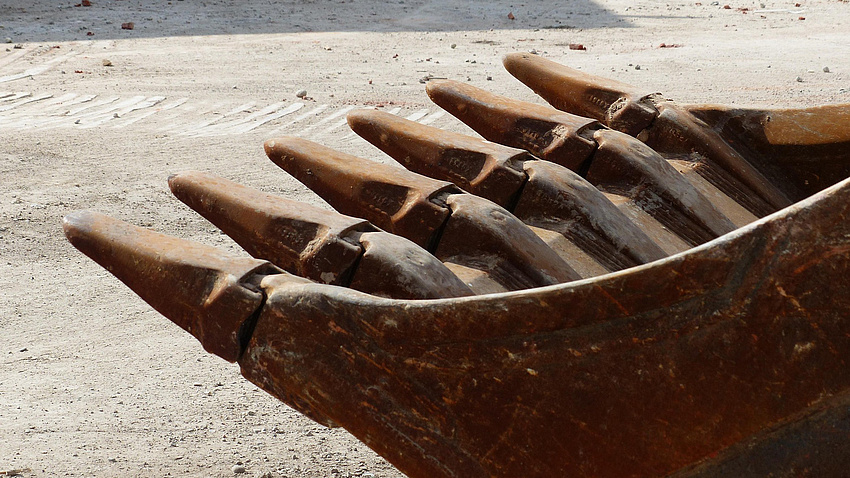 Eine Baggerschaufel ist in Nahaufnahme zu sehen.