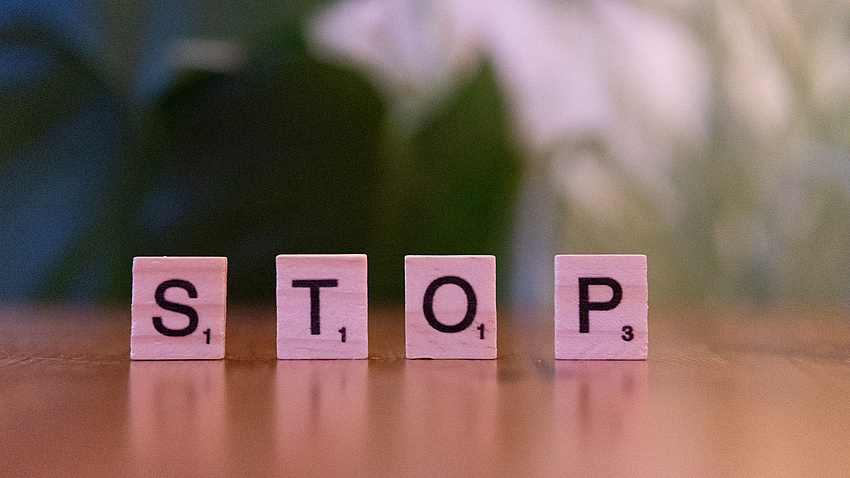 Zu lesen ist das Wort Stop, aufgestellt aus Scrabble Steinen