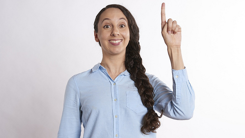 Junge Frau mit gehobenem Zeigefinger