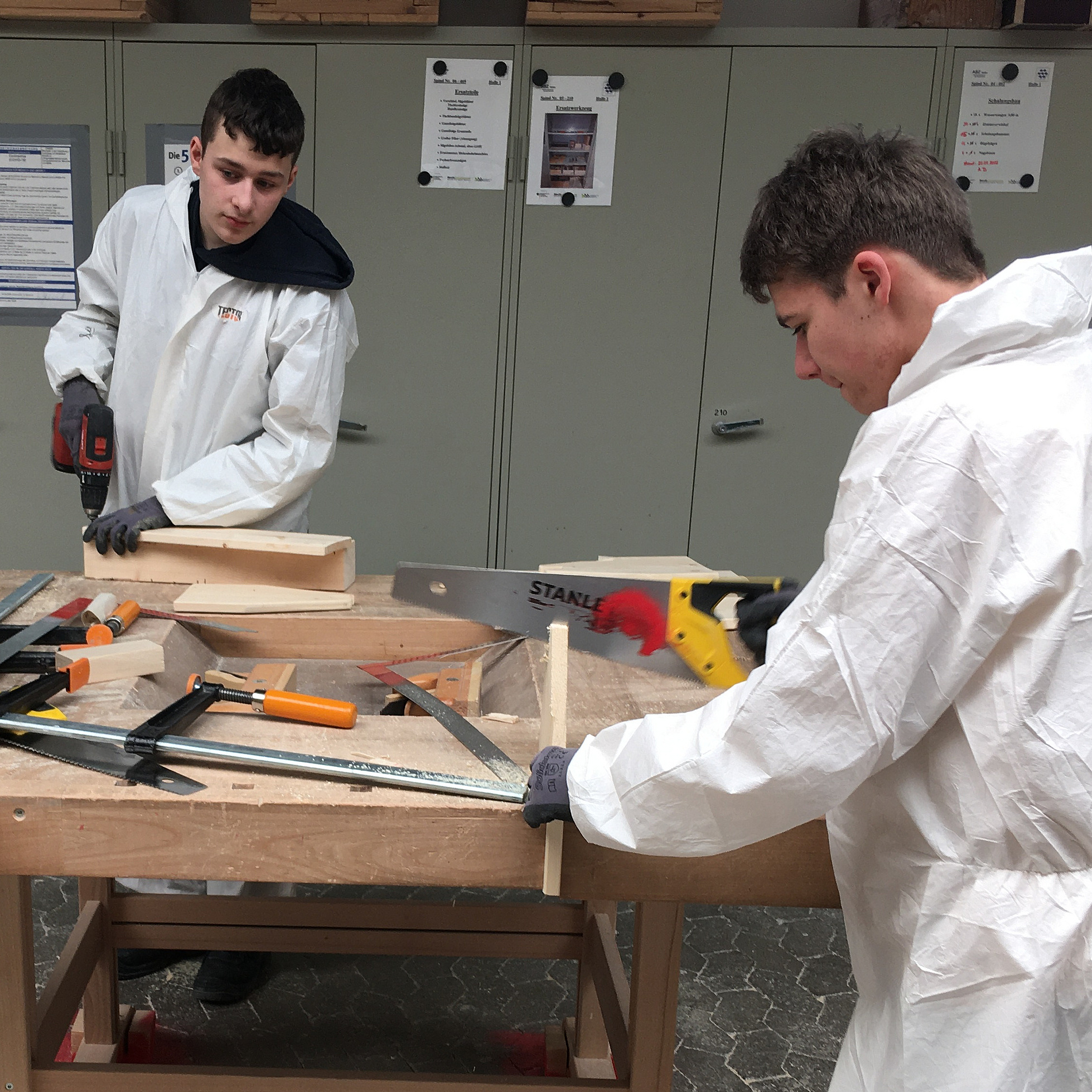 Zwei Jugendliche bauen eine Werkzeugkiste aus Holz
