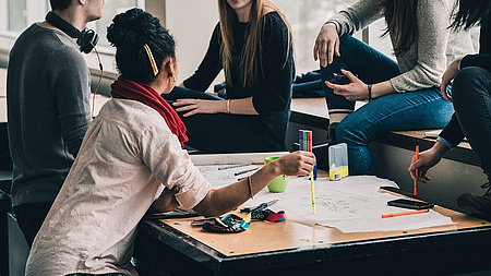 Junge Menschen arbeiten an einer Gruppenarbeit im Büro