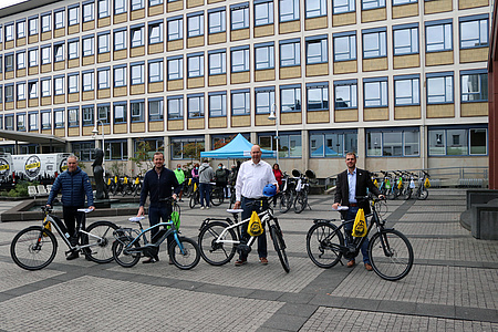 Vier Männer mit Fahrrädern. In Hintergrund die Fahrräder, die für die Aktion zur Verfügung standen