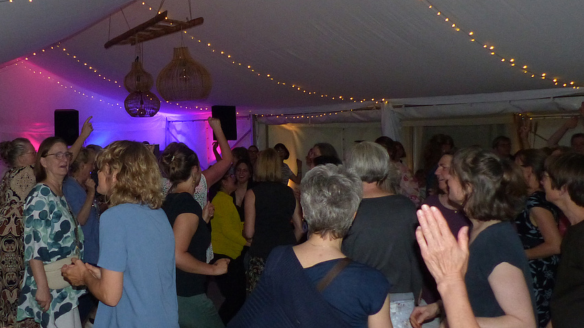 Ein Partyzelt. Darin tanzende Frauen.