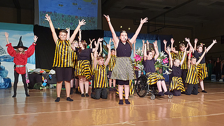 Kinder in Kostümen auf einer Bühne.