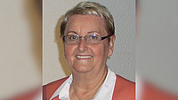 Eine Dame mit Brille lächelt in die Kamera.