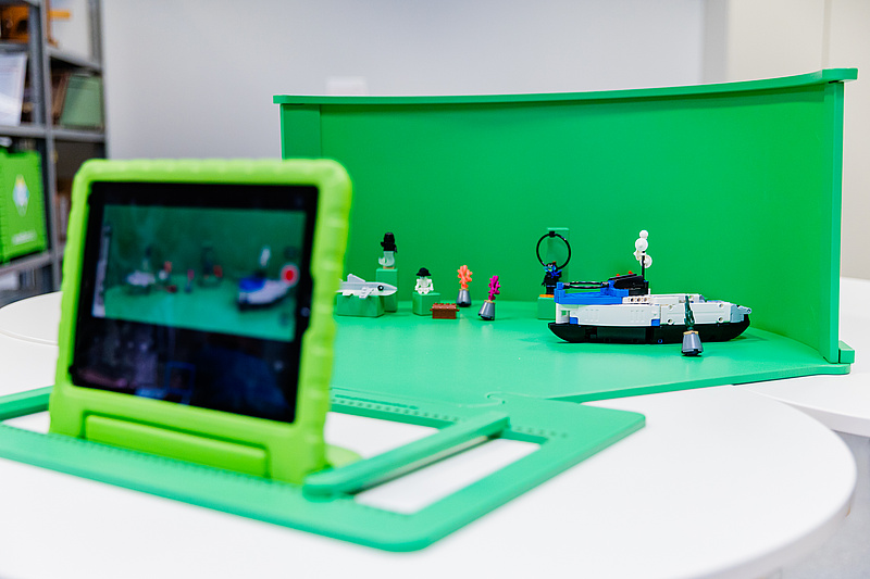 Eine Greenscreenbox mit einem iPad und LEGO Bausteinen.