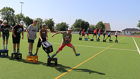 Eine Gruppe Jungen spielt auf einem Sportfeld ein Spiel.