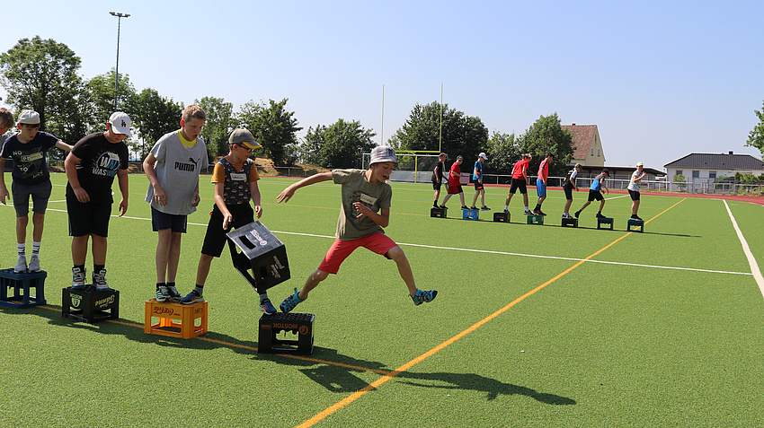 Eine Gruppe Jungen spielt auf einem Sportfeld ein Spiel.