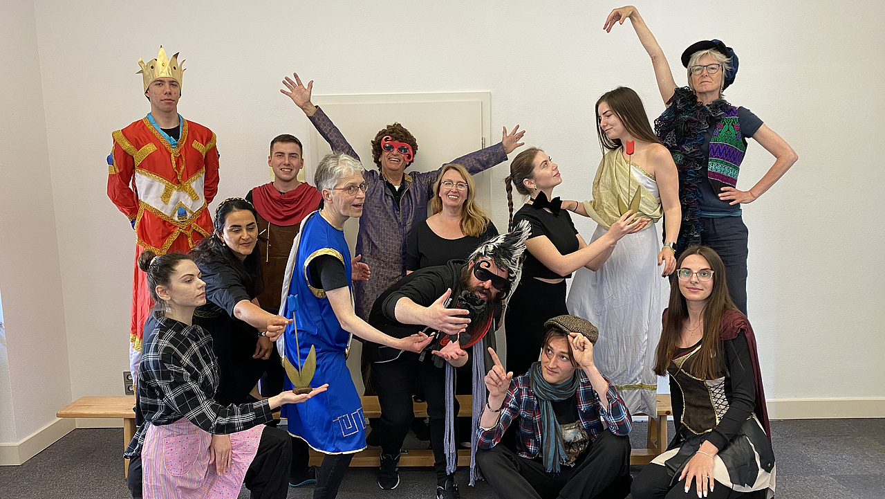 Menschen in Theaterkostümen posieren