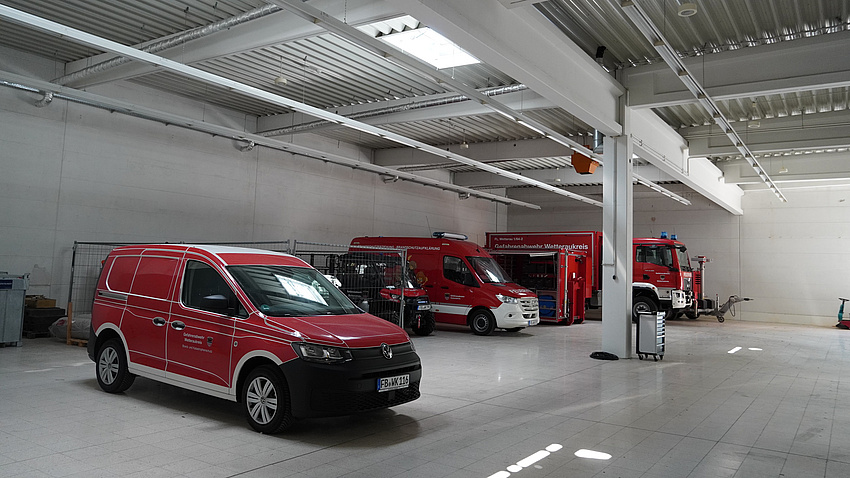 Rote Einsatzwagen in einer Halle.