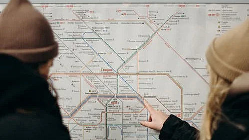 Zwei Jugendliche vor einem Streckenplan der Bahn.